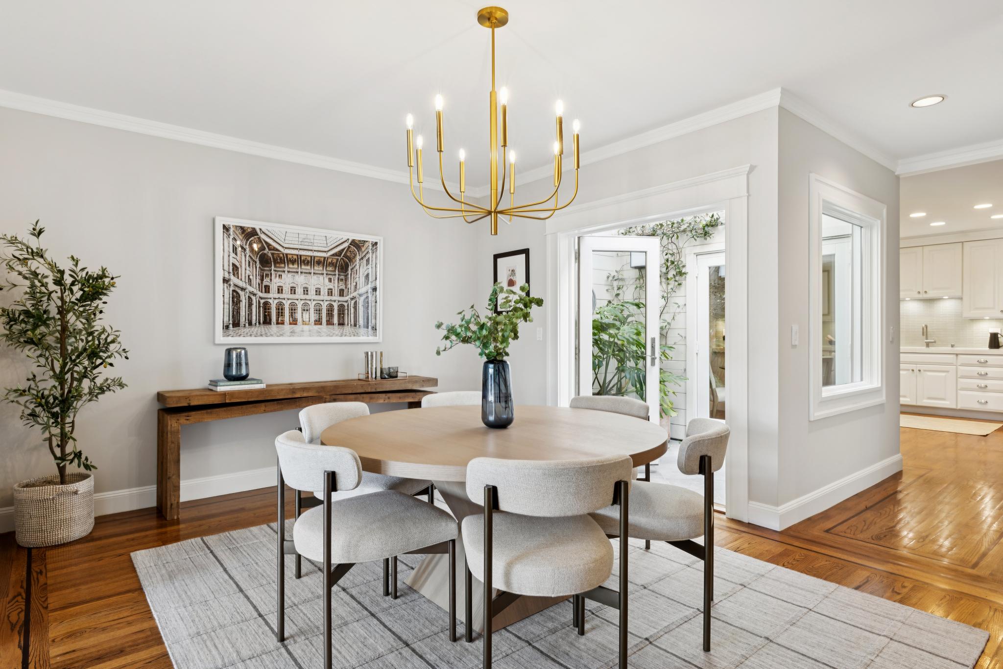 Formal dining room with brass chandelier and French doors to the interior patio
