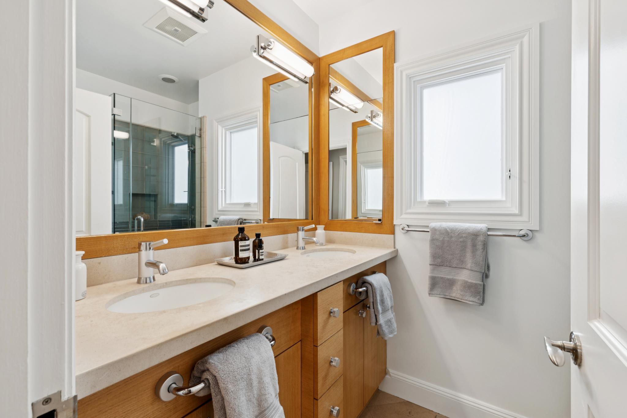 Primary bathroom with dual vanity and glass-enclosed shower