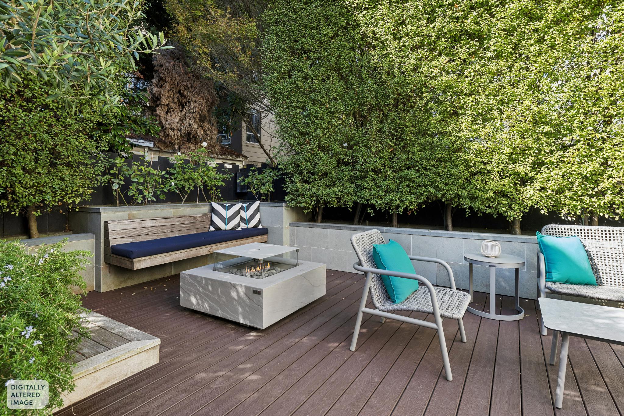 Elementi fire pit table surrounded by mature greenery